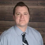 Jesse Lange, web designer, in professional headshot wearing light blue shirt and tie.