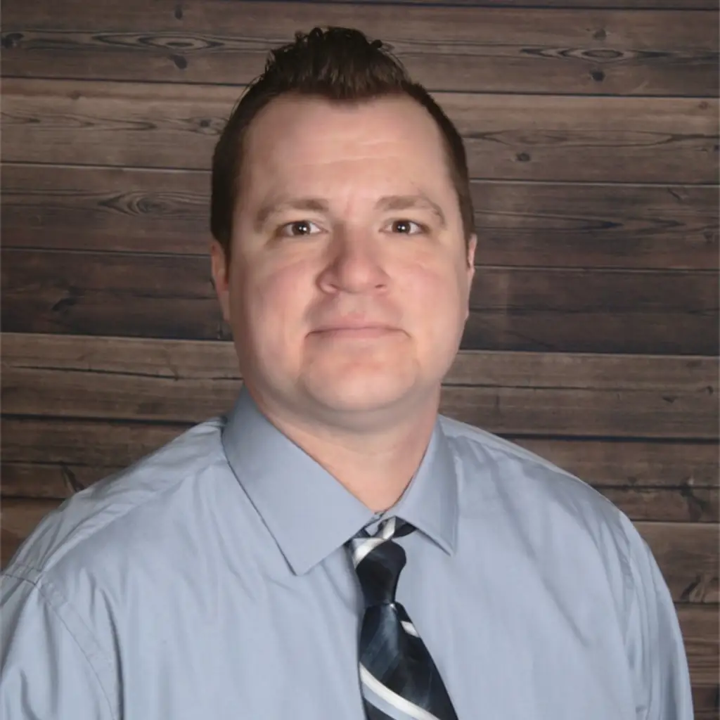Jesse Lange, web designer, in professional headshot wearing light blue shirt and tie.